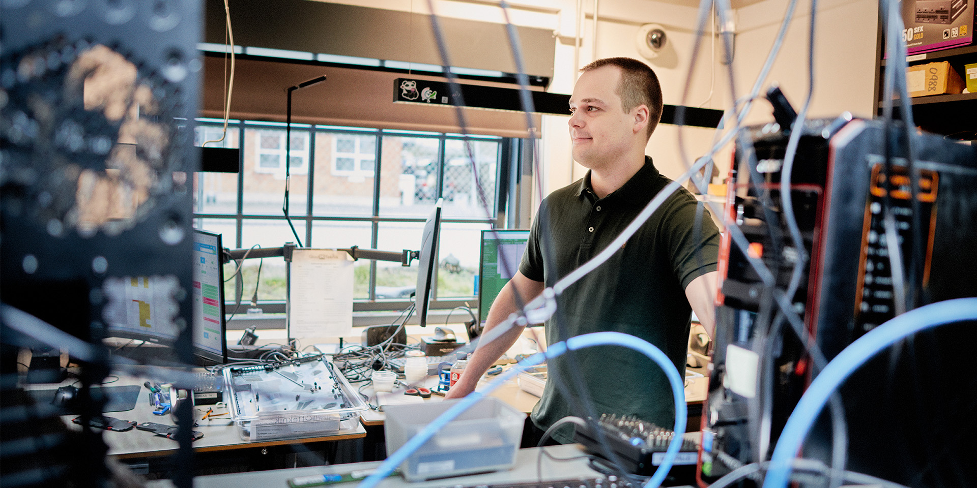 Stifter og ejer af Glad Teknik Mathias Nielsen står på kontoret og ser på ledninger