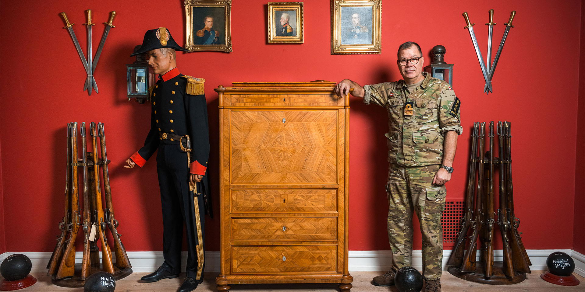 Henrik Rybjerg læner sig op ad en kommode i blandt søfartens historiske genstande