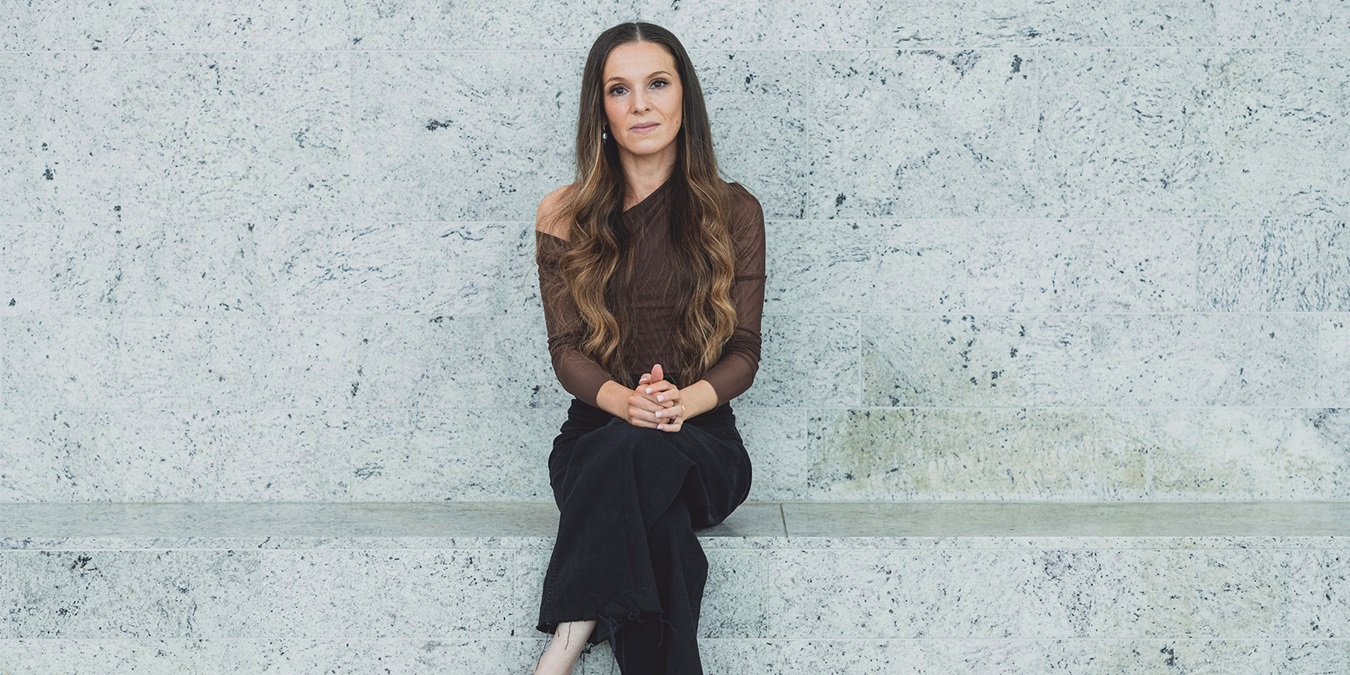 Feminas chefredaktør Isabella Hindkjær sidder på en stenbænk