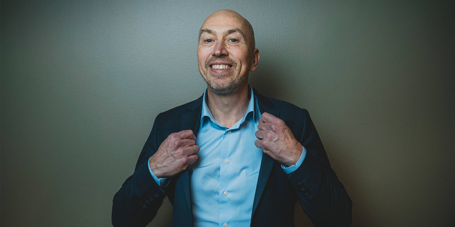 Jakob Keinicke Sørensen smiler til kameraret og holder i kraven på hans skjorte