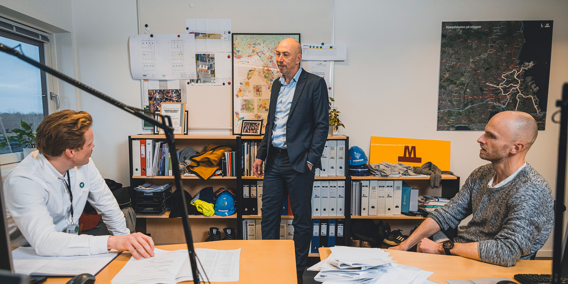 Jakob Keinicke Sørensen står på kontoret og snakker med to medarbejdere