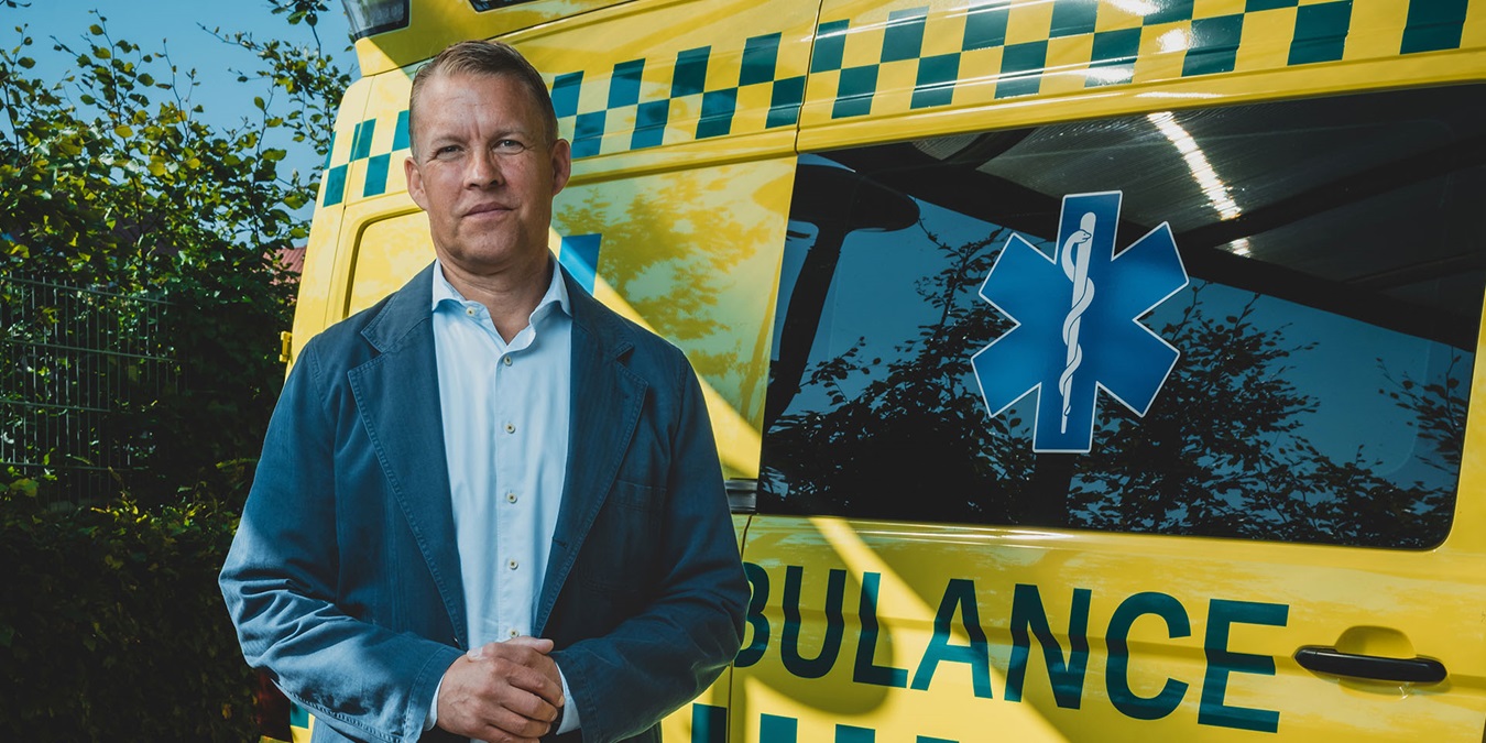 Jakob Riis står ved en ambulance