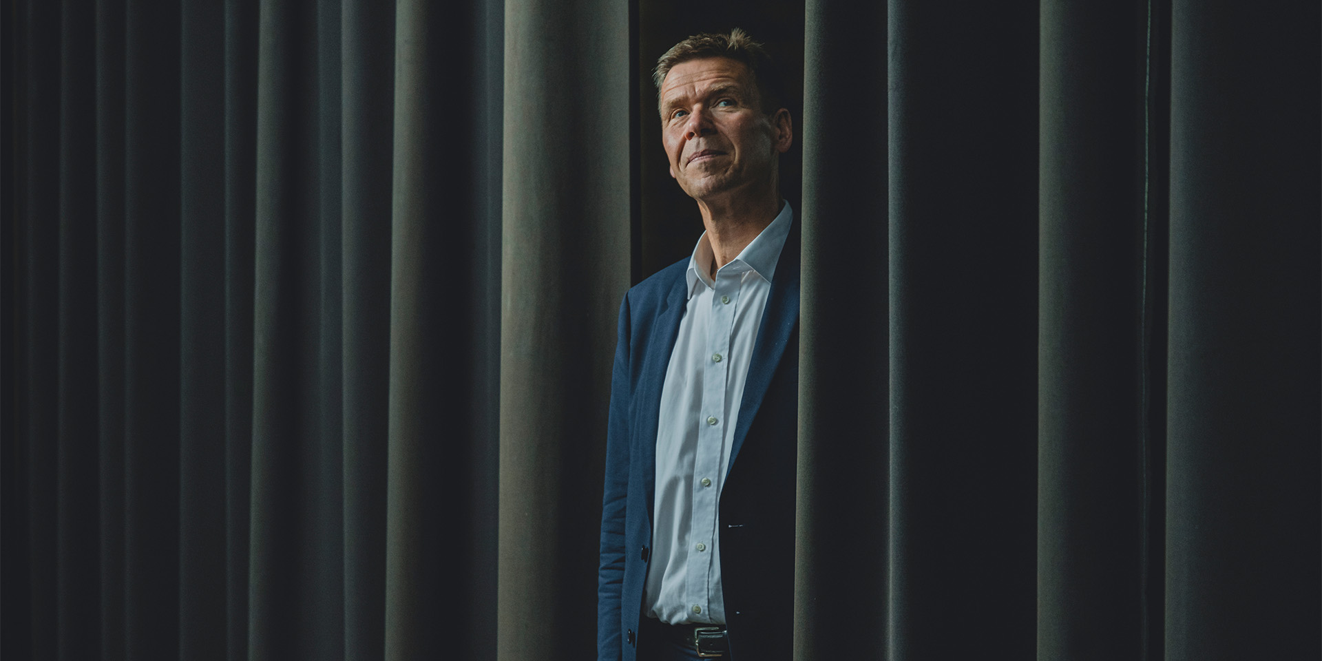 Nomineret til Årets Leder 2022, Jesper Hjulmand står halvt bag et gardin