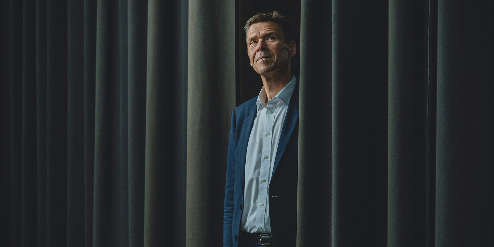 Nomineret til Årets Leder 2022, Jesper Hjulmand står halvt bag et gardin