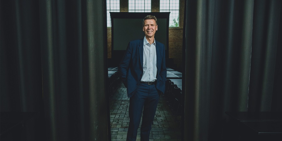 Nomineret til Årets Leder 2022, Jesper Hjulmand står mellem to gardiner og griner