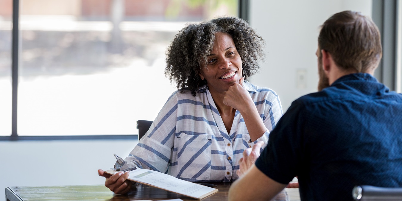 En kvinde interviewer en mand til en jobsamtale