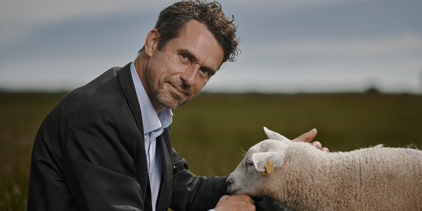 Jonas Engberg sidder på en mark med et lam