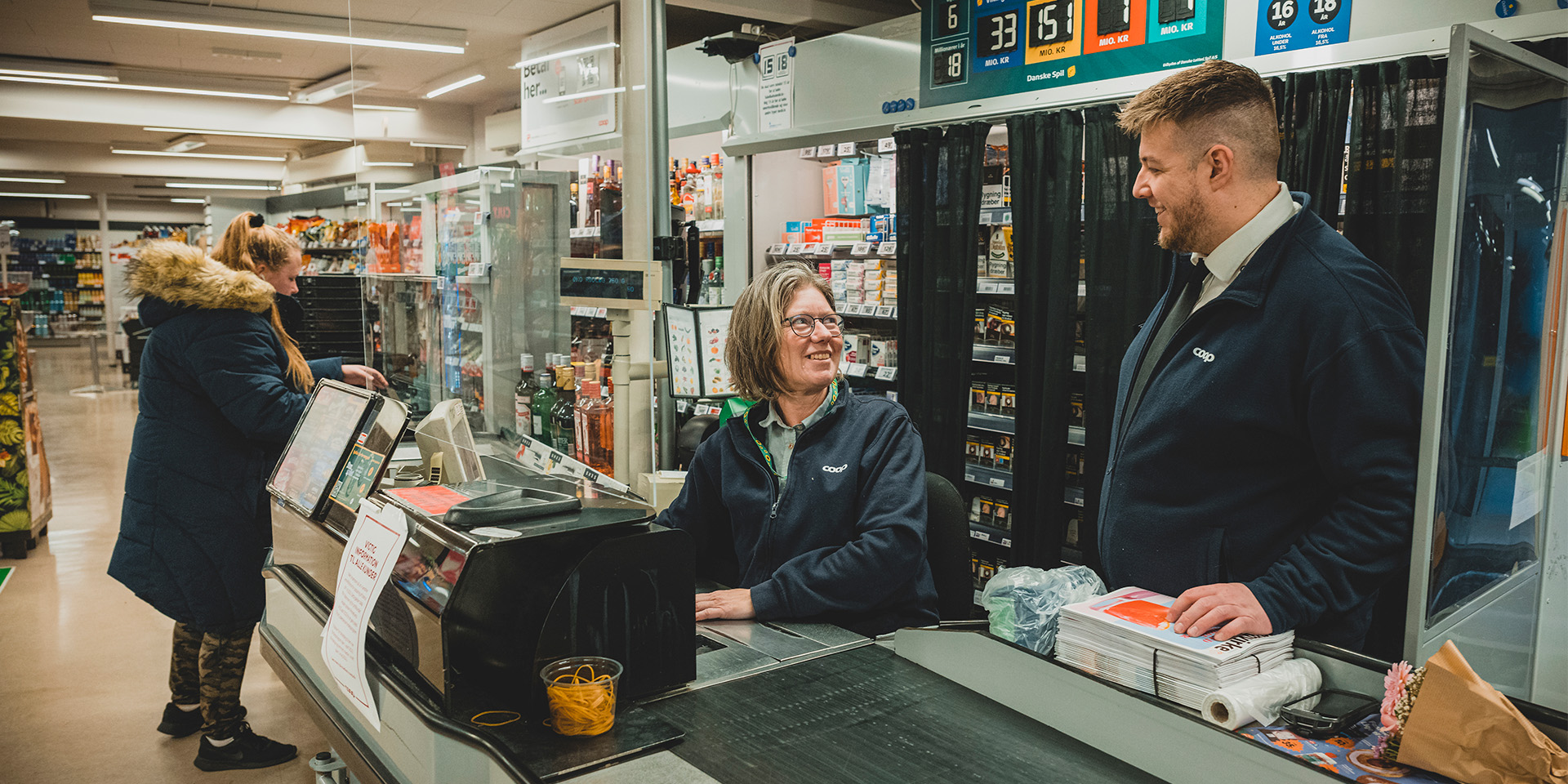 Jonas Schmidt står ved kassen med en medarbejder