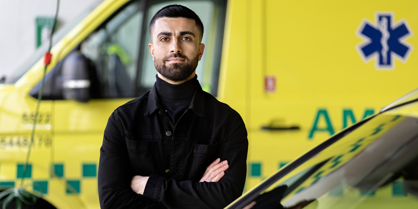 Karvan Shojaeipoor står foran en ambulance