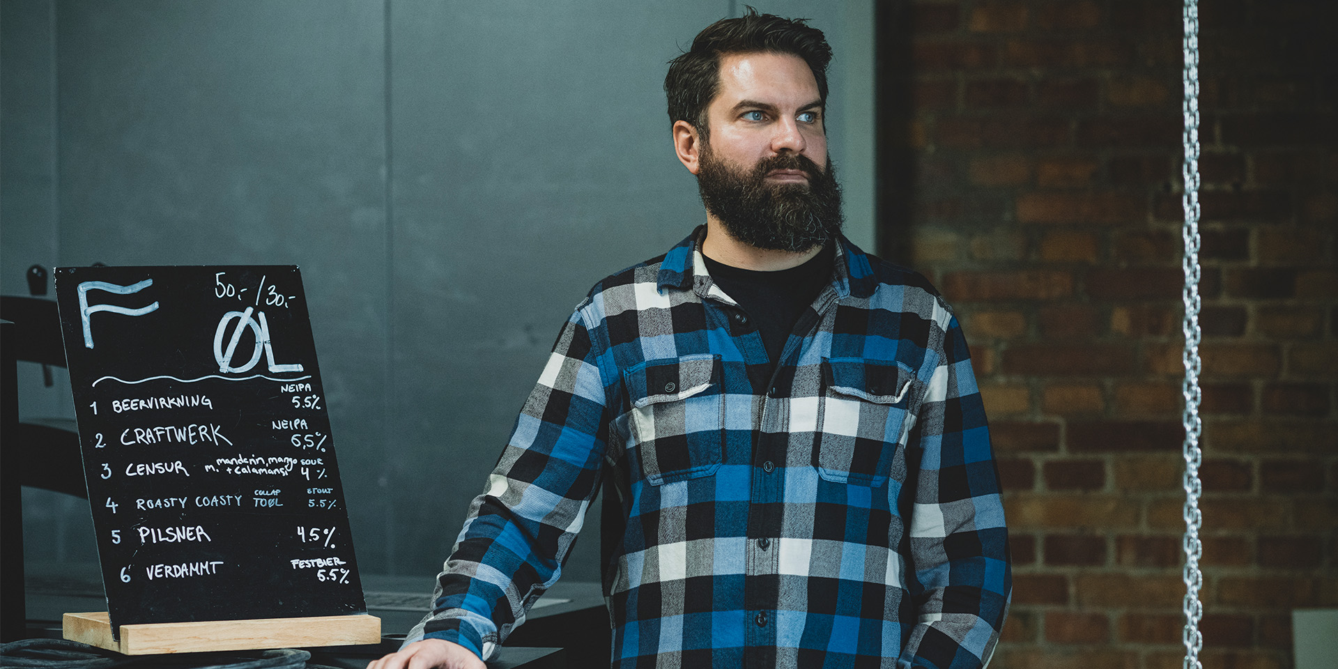 Kasper Gerdes står ved siden af øl menu skilt