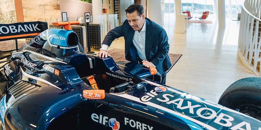 Kim Fournais står ved siden af en Formel 1 bil på Saxo Banks kontor