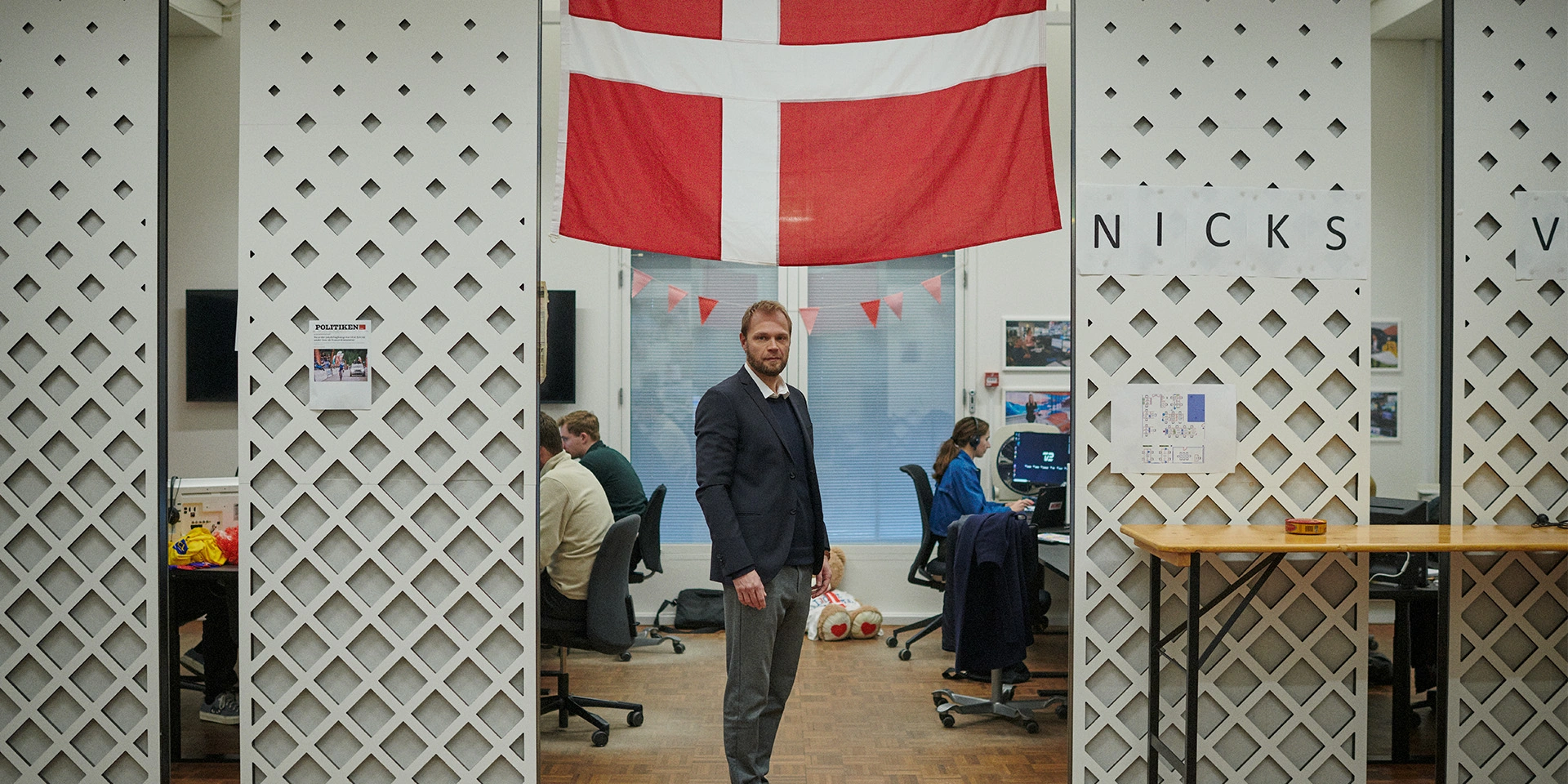 Kristian Bech Josefsen står på TV2s kontor under et dannebrogsflag