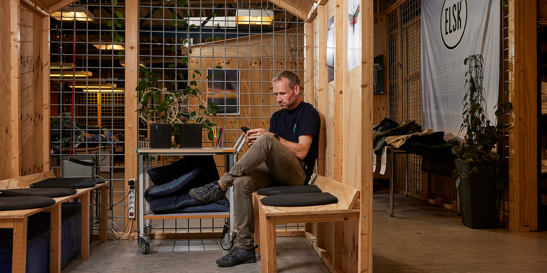 Lars Riis sidder på en bænk på ELSK's kontor med sin telefon