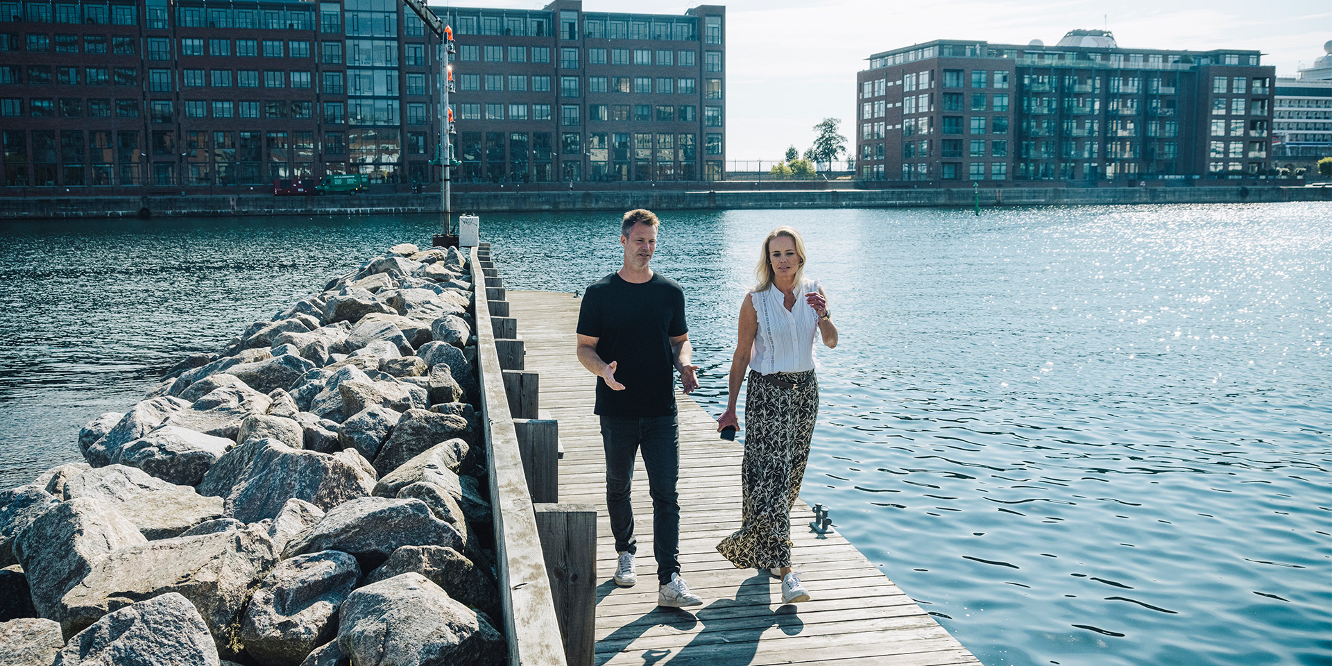 To kollegaer fra LB forsikring går en tur langs vandet for at få en pause