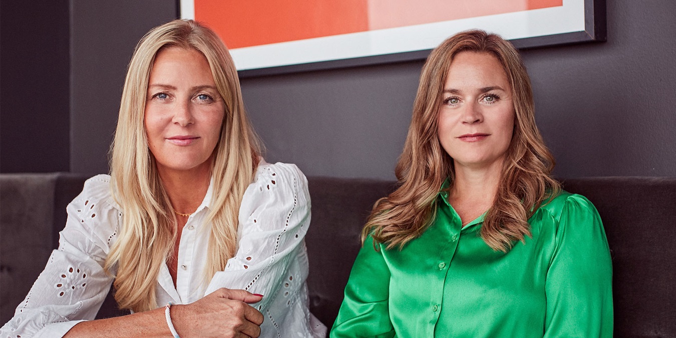 Louise Dinesen og Vibeke Lunding-Gregersen sidder i en sofa