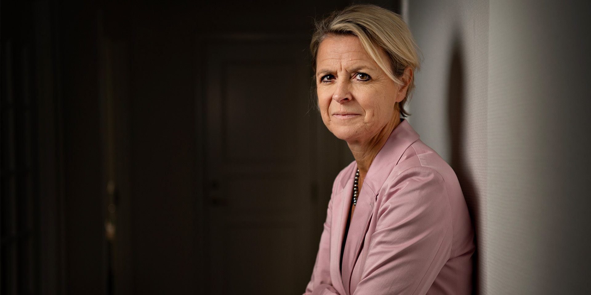 Lykke Friis står med ryggen mod en væg og ser ind i kameraret