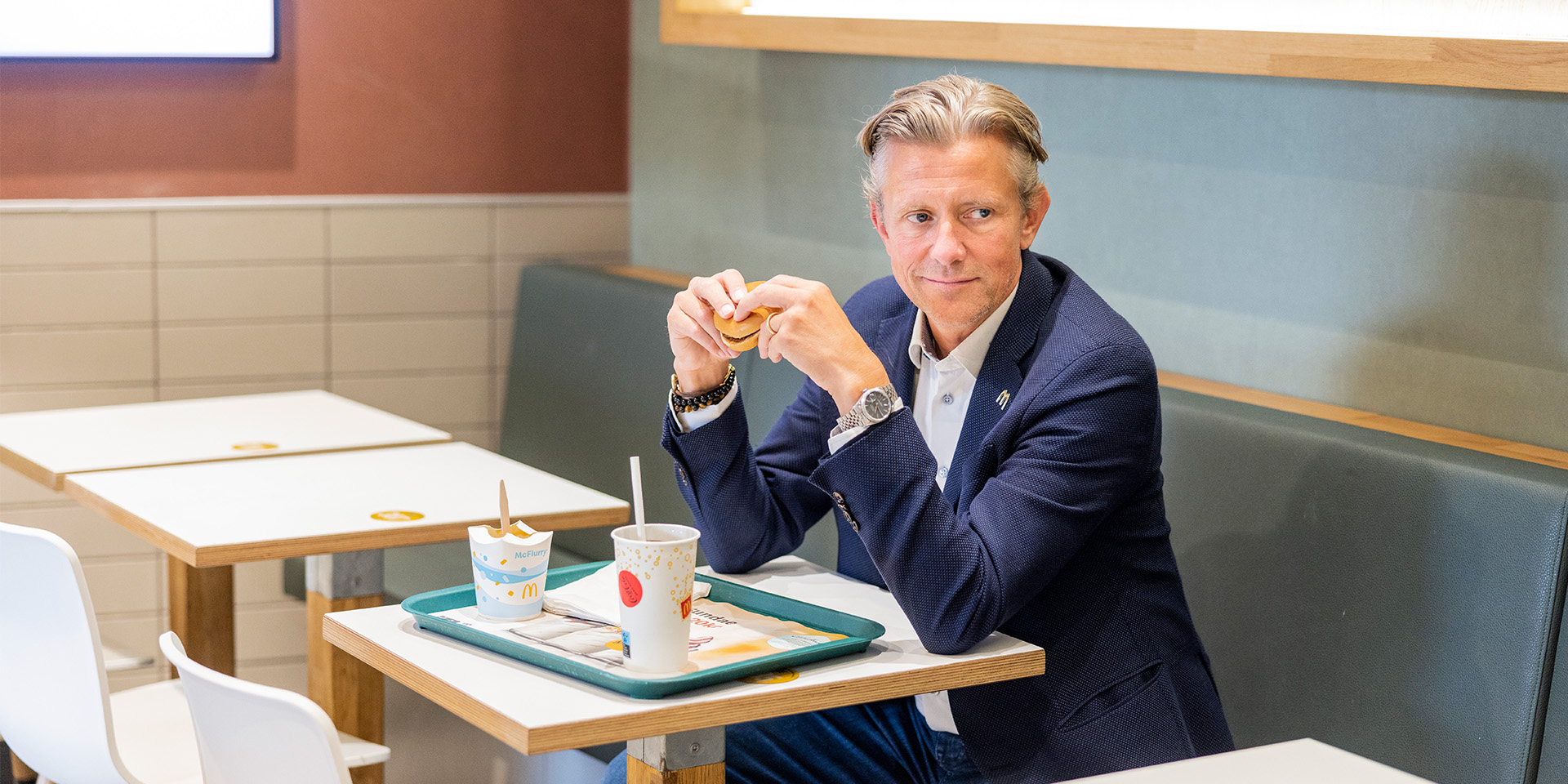 Mads Friis sidder og spiser burger på McDonalds
