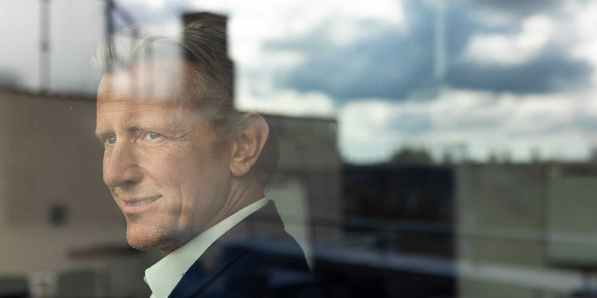 Mads Friis står og ser ud af vinduet