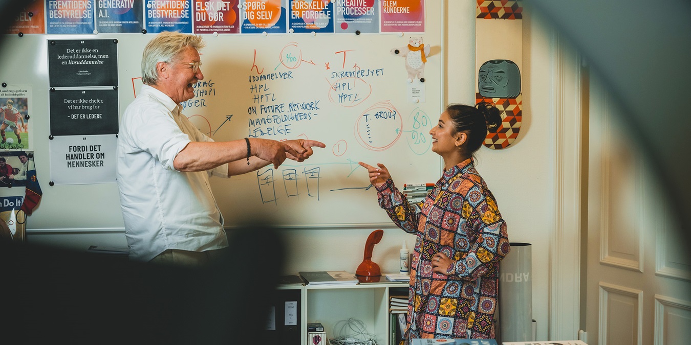 Allan Levann og Mina Akbari peger entusiastisk på hinanden 