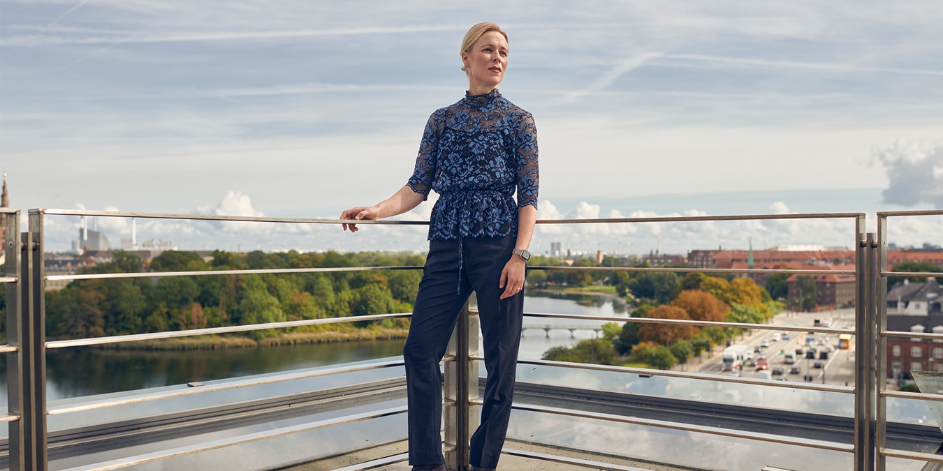 Erhvervsretoriker Mette Højen står på en balkon med udsigt over København