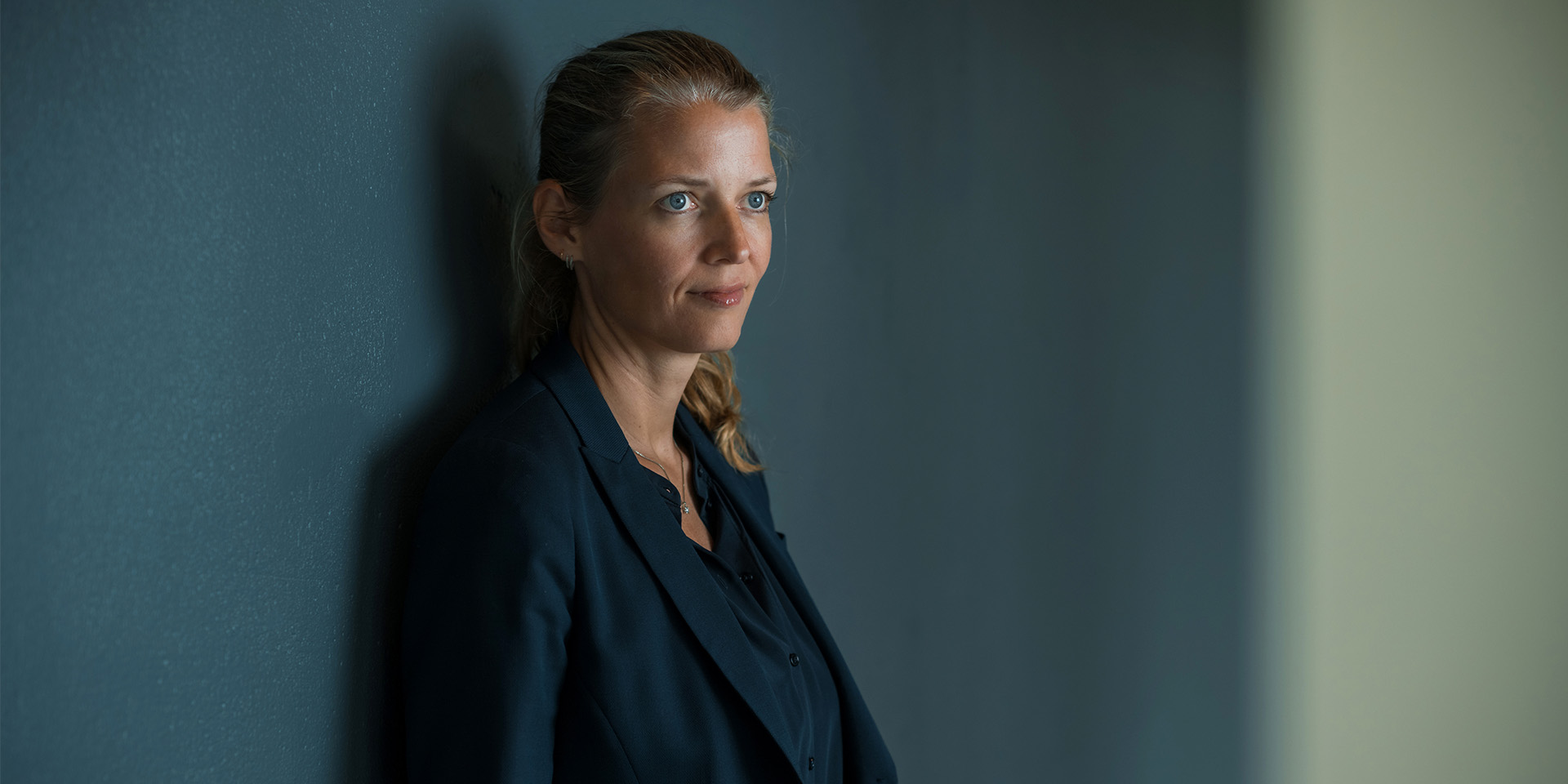 Mette Lykke læner sig op af en væg