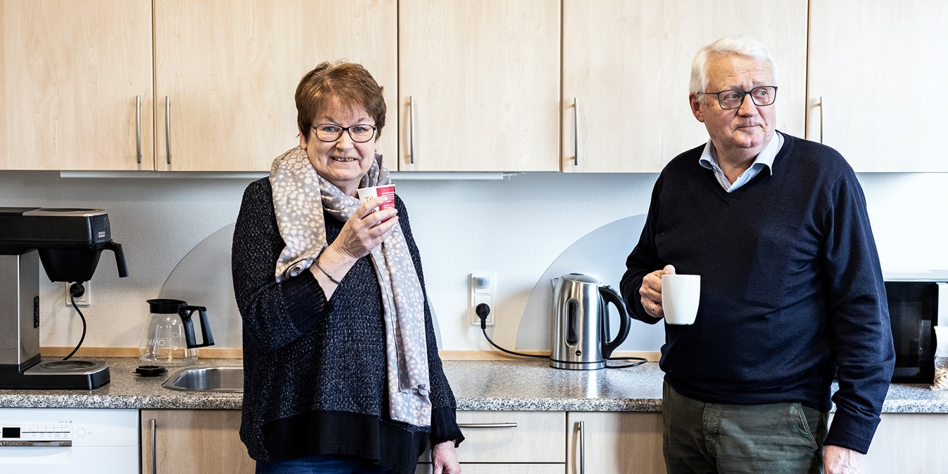 Ilse Møller og Lars Hansen står i Middelfart Sparekasses køkken og drikker kaffer