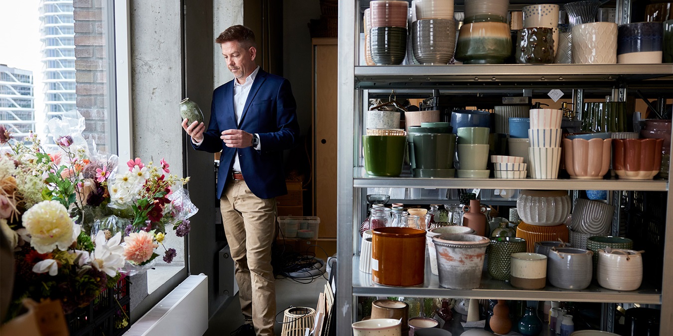 Mikkel Grene står med en potte på Søstrene Grenes lager