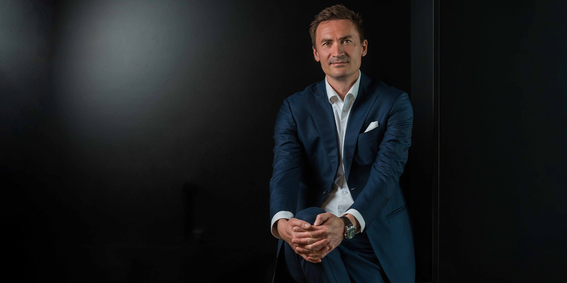 Mikkel Severin sidder foran en sort baggrund