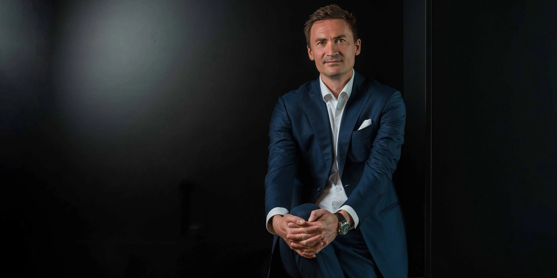Mikkel Severin sidder foran en sort baggrund