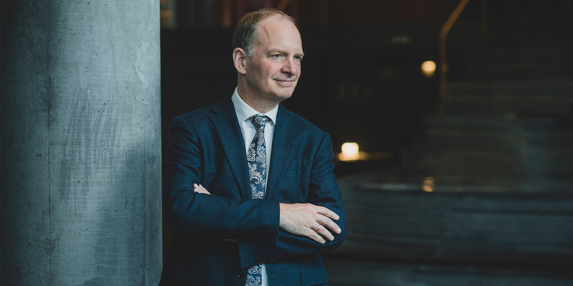 Professor Nicolai Foss står med krydsede arme og skuer ud i horisonten