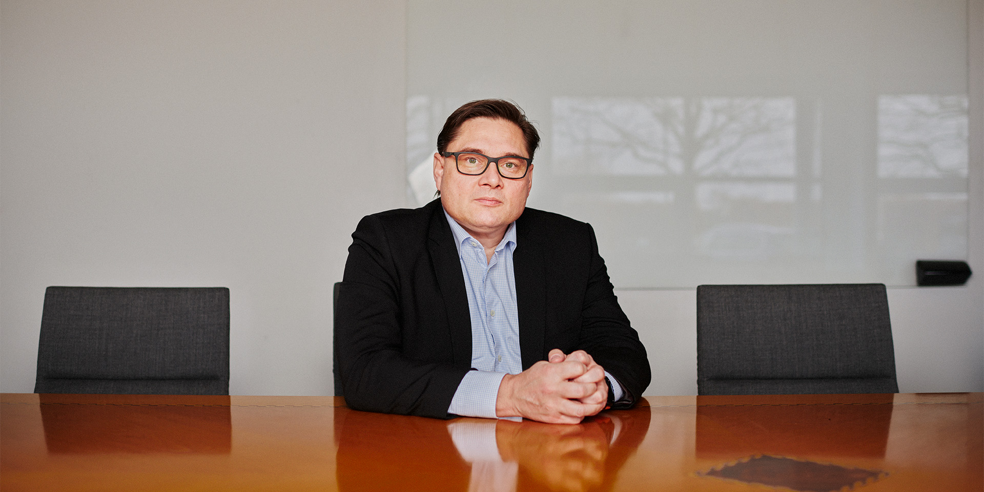 Peter Kjær sidder i et stort mødelokale alene