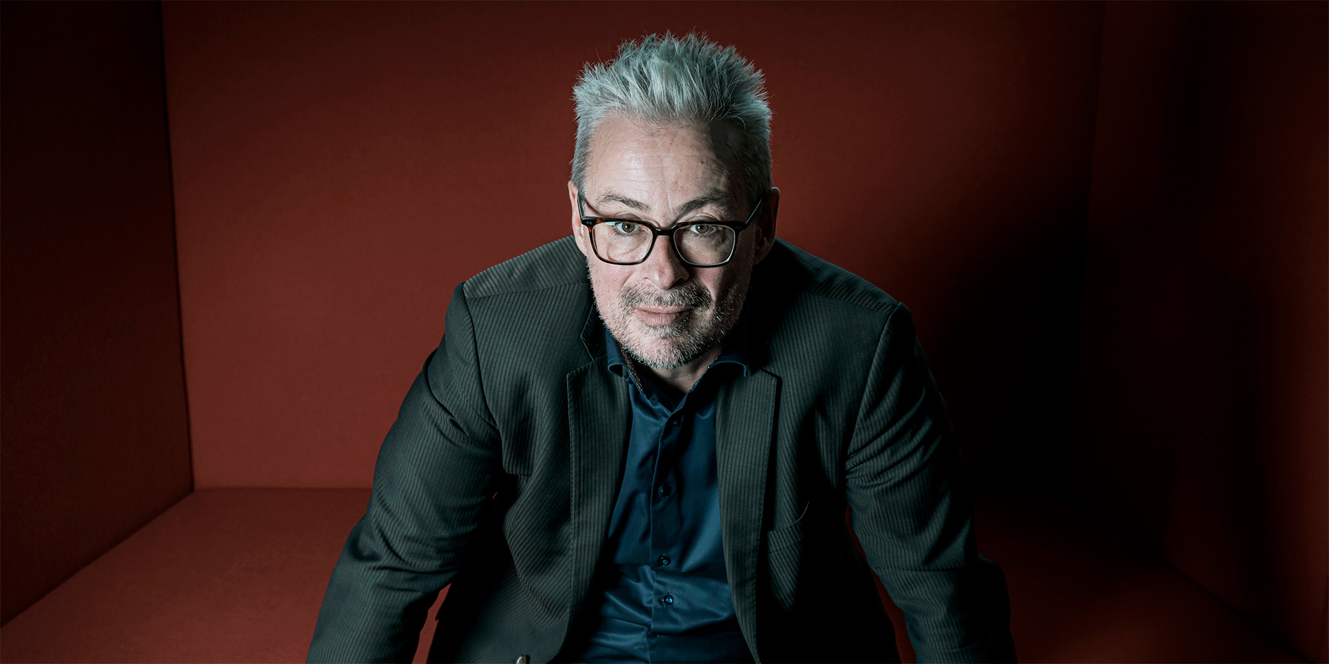 Rane Willerslev sidder i en rød sofa