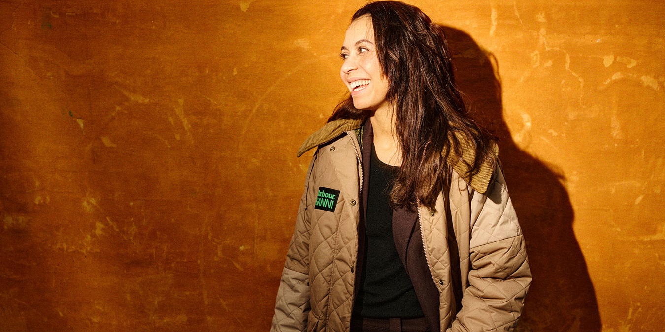 Rebecca Holmberg Jensen griner og står foran en orange væg