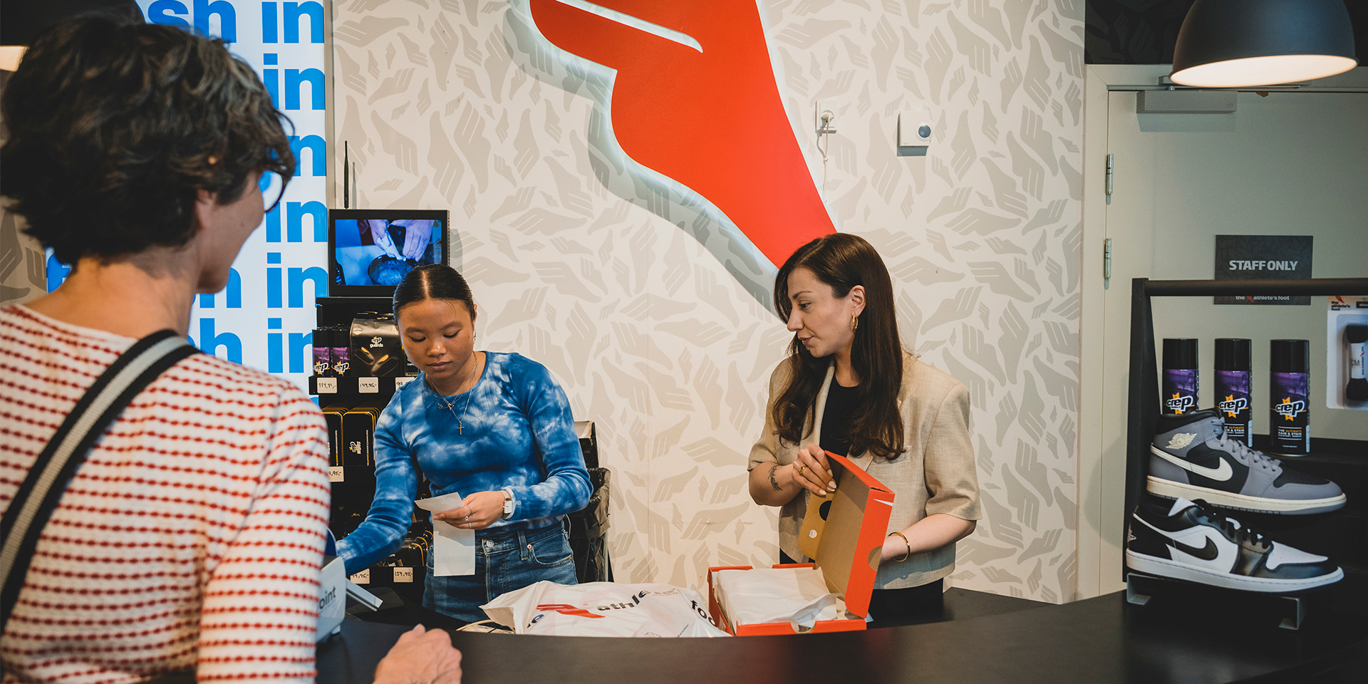 Semanur Kokten står ved kassen og ekspederer en kunde