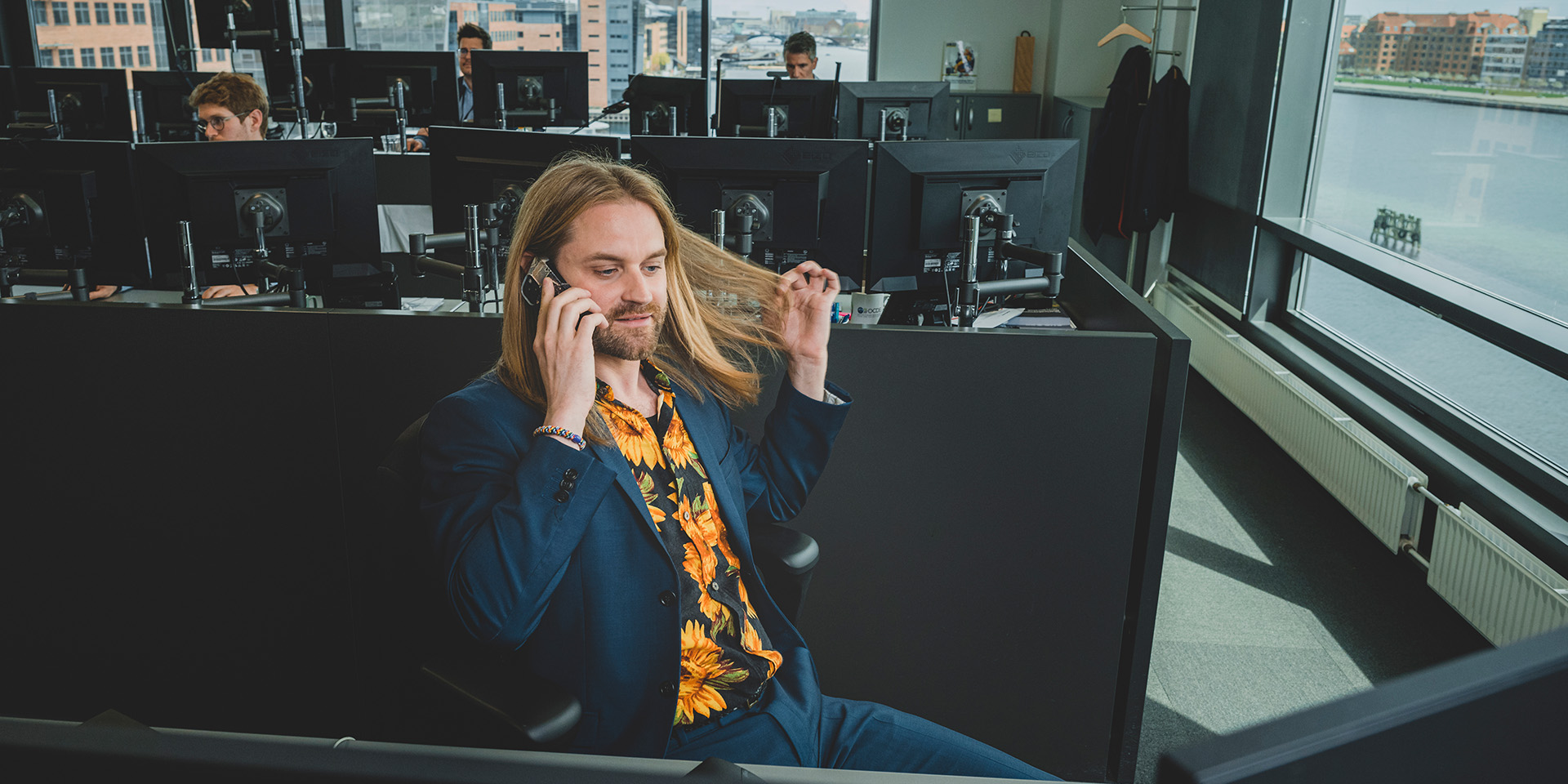 Sune Malthe Thagaard sidder og snakker i telefon mens han nulrer med sit lange hår