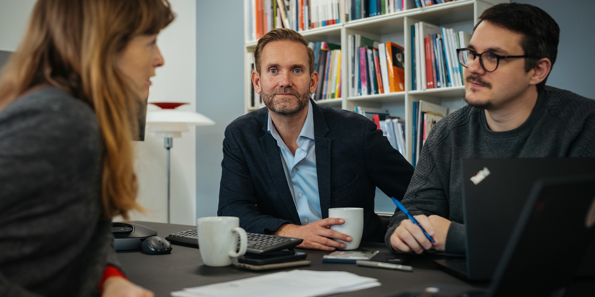 Tommy Zwicky sidder mellem to kollegaer og snakker