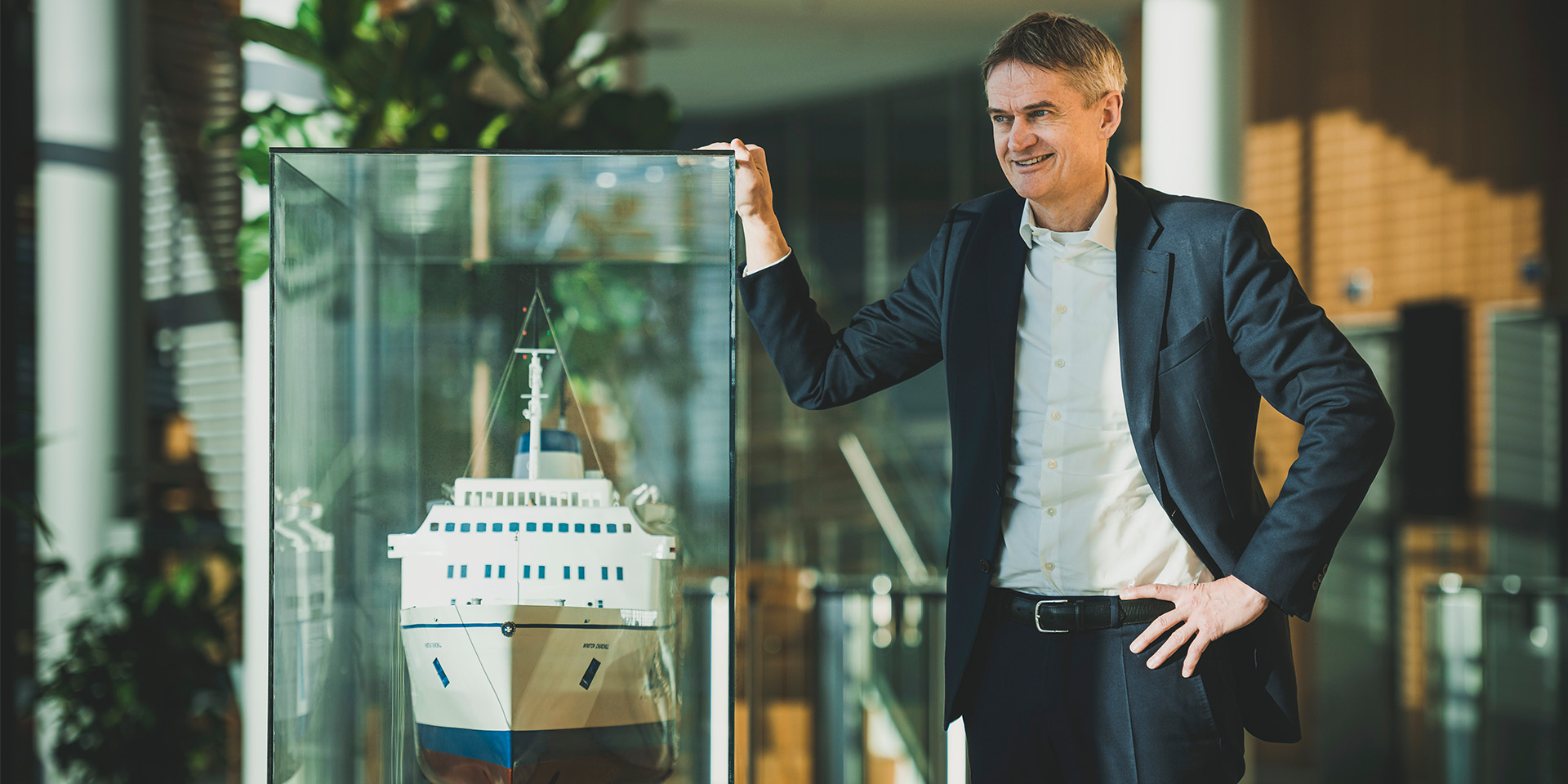 Torben Carlsen på sit kontor med et modelskib i en glaskasse
